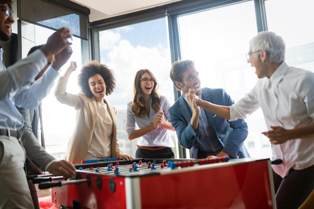 Employees playing table soccer in the office showing gamification examples
